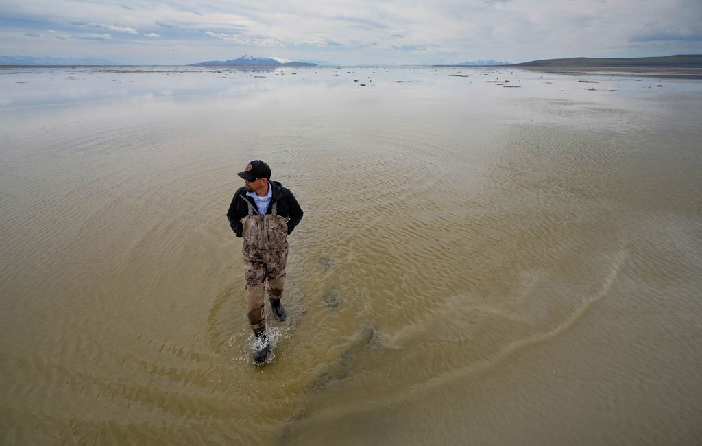 (Francisco Kjolseth | The Salt Lake Tribune) Ducks Unlimited Regional Director Chad Yamane walks the shallow edges of the Great Salt Lake near the outflow of the Weber River following a record breaking snow year on Wednesday, April 12, 2023. Critical wetlands that were bone-dry just weeks before have slowly come back with a few inches of water, as much attention is paid to how much the terminal lake will recover.